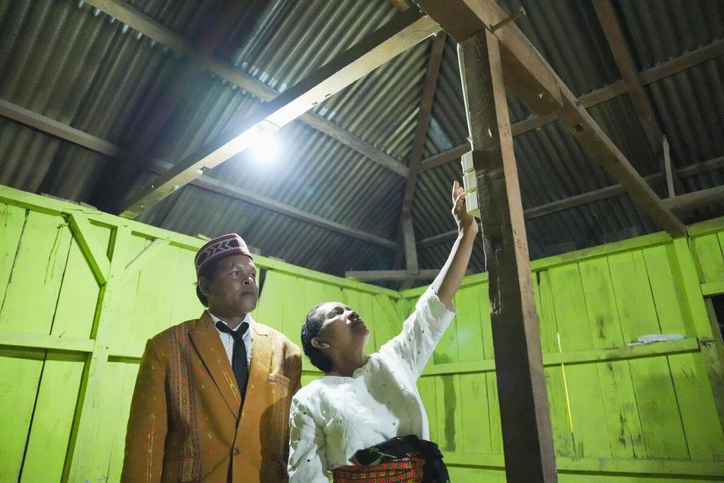 Seorang ibu rumah tangga di Desa Golo Lanak, Kabupaten Manggarai, Nusa Tenggara Timur, menyalakan listrik di rumahnya saat peresmian kehadiran listrik di lima desa di Manggarai, Jumat (10/11/2023).
