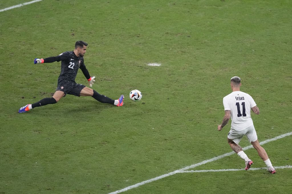 Penjaga gawang Portugal Diogo Costa menyelamatkan gawangnya dari ancaman pemain slovenia. 