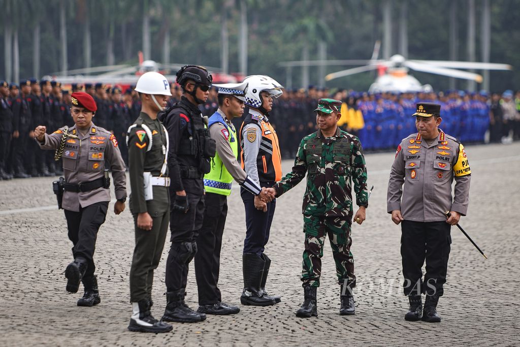 Panglima TNI Jenderal Agus Subiyanto (kedua dari kanan) berjabat tangan dengan perwakilan anggota Polri disaksikan Kapolri Jenderal Listyo Sigit Prabowo (kanan) dalam apel gelar pasukan Operasi Ketupat 2024 di kawasan Monas, Jakarta, Rabu (3/4/2024). 