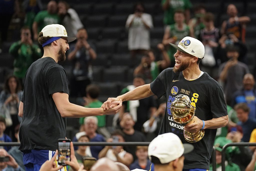 Dua <i>guard </i>Golden State Warriors, Stephen Curry (kanan) dan Klay Thompson, merayakan sukses mereka mengantar Warriors menjadi juara NBA untuk keempat kalinya dalam delapan musim di TD Garden, Boston, 16 Juni 2022. 