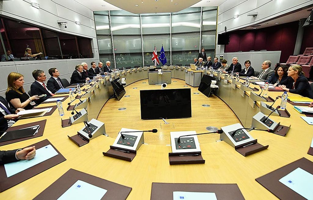 Delegasi Inggris,   yang dipimpin Menteri Urusan Keluar dari Uni Eropa David Davis (barisan kiri), duduk berhadapan dengan delegasi Uni Eropa yang dipimpin ketua juru rundingnya, Michael Barnier, pada hari pertama perundingan Brexit di Markas Komisi Eropa, Brussels, Belgia, 19 Juni lalu. 
