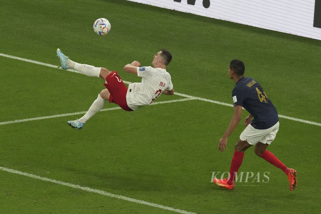 Pemain Polandia, Arkadiusz Milik, melakukan tendangan salto saat melawan Perancis dalam pertandingan babak 16 besar Piala Dunia 2022 di Stadion Al Thumama, Qatar, Minggu (4/12/2022). Perancis melaju ke babak perempat final setelah mengalahkan Polandia 3-1. 