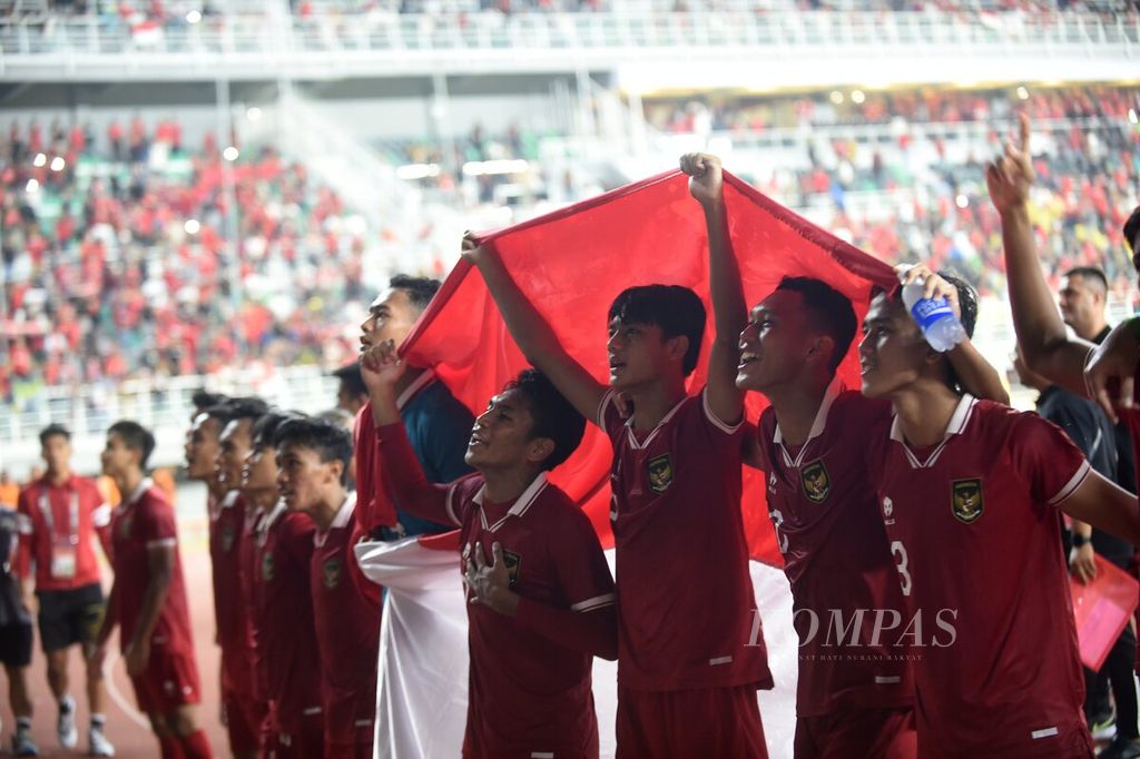 Pemain Indonesia U-19 dengan membawa bendera merah putih merayakan keberhasilan Indonesia lolos ke Piala Asia U-20 setelah mengalahkan Vietnam di Stadion Gelora Bung Tomo, Kota Surabaya, Jawa Timur, Minggu (18/9/2022). Indonesia menang 3-2 dan memastikan Indonesia maju ke putaran final Piala Asia U-20 di Uzbekistan pada 2023.