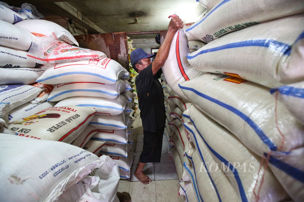 Pekerja mempersiapkan beras di toko beras di Pasar Kebayoran Lama, Jakarta Selatan, Selasa (13/2/2024). Perubahan cuaca, terutama fenomena El Nino yang berkepanjangan, menjadi biang keladi defisit beras.