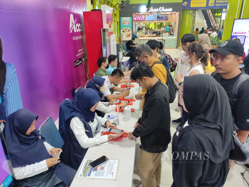 Sejumlah petugas pendaftaran sistem pengenalan wajah melayani penumpang di Stasiun Gambir, Jakarta, Kamis (21/12/2023).