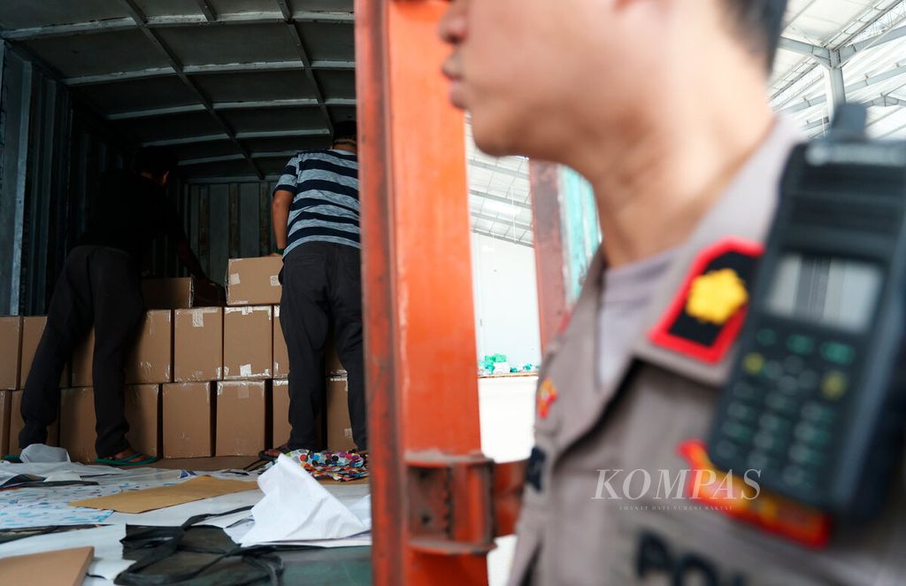 Polisi berjaga saat proses penurunan logistik pemilu berupa kertas segel di Gudang KPU, Ngaliyan, Kota Semarang, jawa Tengah, Kamis (30/11/2023). 