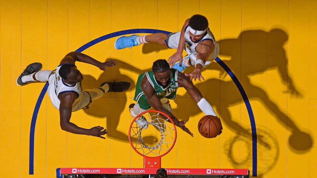 Pemain Boston Celtics, Jaylen Brown (tengah), mencoba memasukkan bola saat bertanding melawan Golden State Warriors pada laga pertama Final Bola Basket NBA di Chase Center, San Francisco, Jumat (3/6/2022) pagi WIB. 