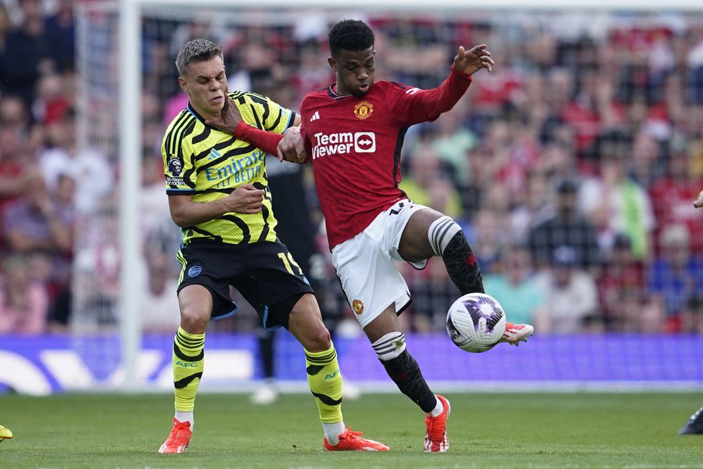 Pemain Arsenal, Leandro Trossard (kiri), berebut bola dengan pemain Manchester United, Amad Diallo, pada laga Liga Inggris di Stadion Old Trafford, Manchester, Senin (13/5/2024) dini hari WIB. Arsenal menang 1-0 pada laga itu.