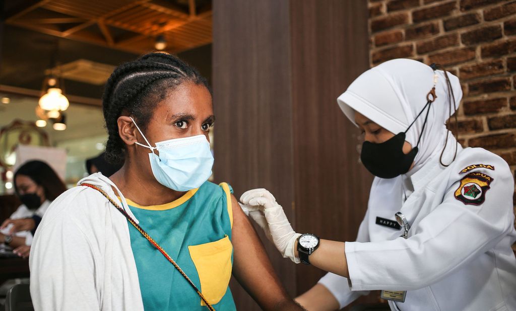 Para pelajar mengikuti vaksinasi massal Covid-19 di sebuah pertokoan di kawasan Waena, Distrik Heram, Jayapura, Selasa (30/11/2021). 