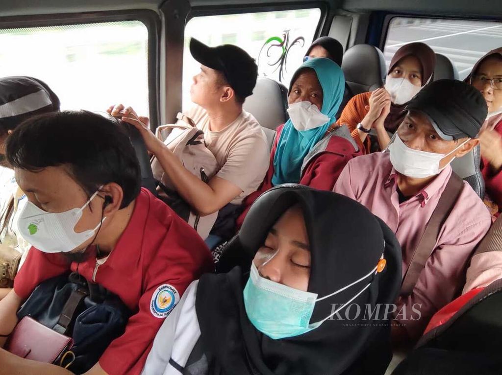 Beberapa karyawan tertidur di dalam minibus yang sesak saat menempuh perjalanan dari Jakarta menuju Serang, Banten, Kamis (30/3/2023).