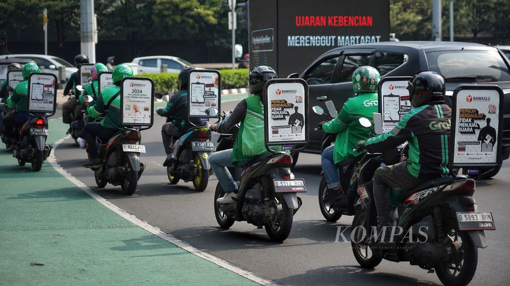 Di sejumlah sepeda motor ojek daring terpasang pesan iklan layanan masyarakat Badan Pengawas Pemilu saat melintasi Bundaran Hotel Indonesia, Jakarta, Jumat (29/12/2023). 