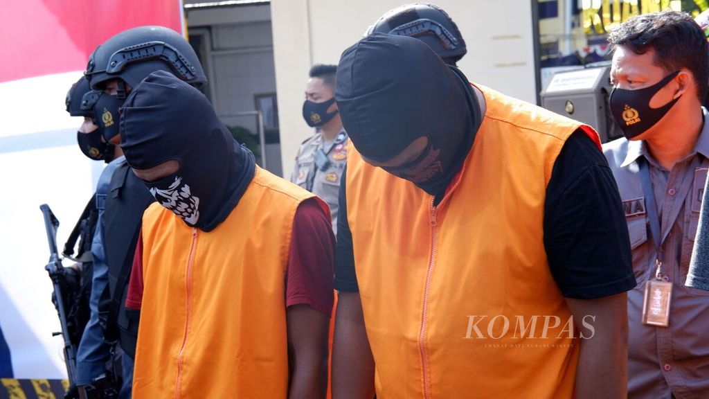 Dua dari empat tersangka pengedar narkoba jaringan internasional (rompi oranye) tertunduk di Lapangan Markas Kepolisian Daerah Kalimantan Selatan, Kota Banjarmasin, Jumat (7/8/2020). Dari empat tersangka itu, polisi menyita sabu 300 kilogram, sehari sebelumnya. 