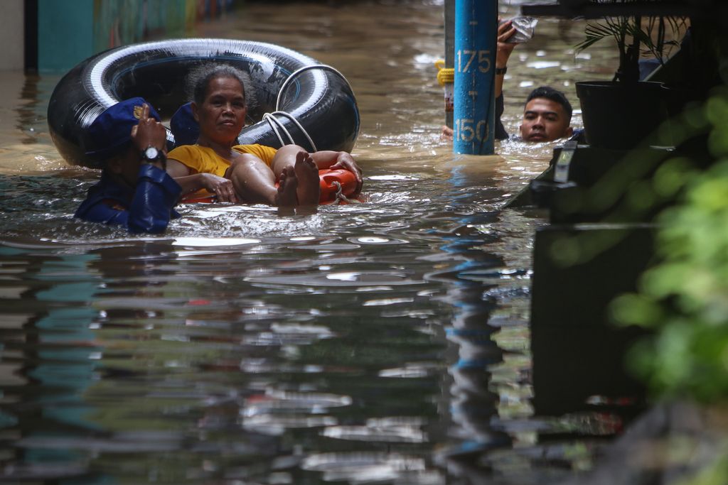 Petugas mengevakuasi  warga lansia yang terjebak banjir di Kampung Melayu, Jatinegara, Jakarta Timur, Senin (27/2/2023). 