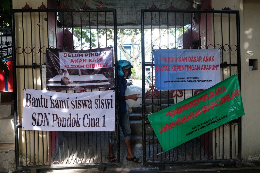 Sejumlah spanduk bernada protes terhadap rencana penggusuran terpasang di pagar SDN Pondok Cina 1, Depok, Jawa Barat, Senin (12/12/2022). 