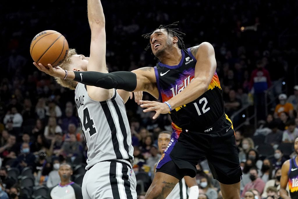 <i>Forward</i> Phoenix Suns, Ishmael Wainright, mencoba melempar bola melewati <i>center</i> San Antonio Spurs, Jock Landale, dalam pertandingan NBA antara Phoenix Suns dan San Antonio Spurs di Phoenix, Minggu (30/1/2022) waktu setempat. Suns mengalahkan Spurs, 115-110.