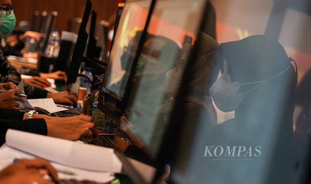 Pantulan bayangan sejumlah petugas KPU yang ditugaskan melakukan verifikasi administrasi dokumen persyaratan partai politik calon peserta Pemilu 2024 di Hotel Borobudur, Jakarta, Minggu (7/8/2022). 