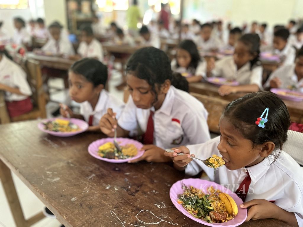 Anak-anak di Sekolah Dasar Inpres Lewoneda di Desa Mudakeputu, Kecamatan Ile Mandiri, Flores Timur, tengah menikmati makan siang bersama dengan menu pangan lokal, Senin (5/3). 