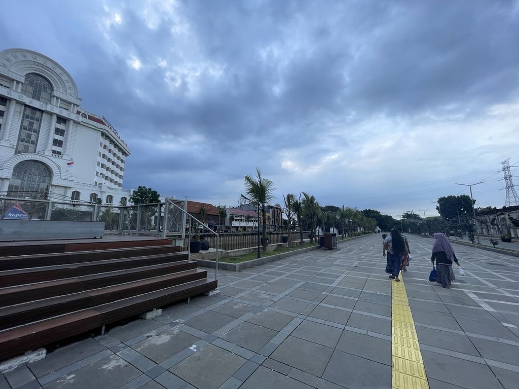 Pengunjung berjalan di area samping Kali Besar Timur di Desa Pinangsia, Kecamatan Taman Sari, Kota Jakarta Barat, Rabu (29/3/2023).