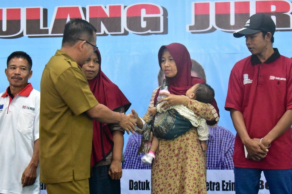 Kepala Dinas Ketenagakerjaan dan Transmigrasi I Gede Putu Aryadi menyalami keluarga salah satu calon pekerja migran Indonesia yang akan diberangkatkan ke Malaysia pada Senin (29/8/2022). Total ada 204 calon pekerja migran diberangkatkan ke Malaysia untuk bekerja di sektor ladang sawit.