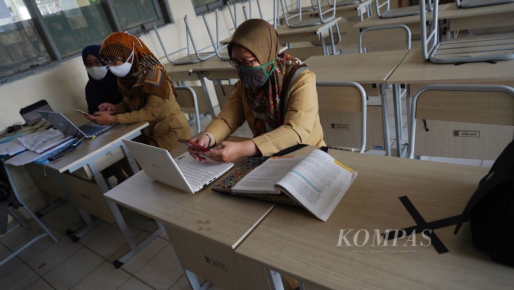 Para guru di SMP Negeri 10, Kota Bogor, Jawa Barat, dengan peralatan laptop dan telepon selularnya, memberikan materi pembelajaran jarak jauh dari sekolah, 24 Agustus 2020.  