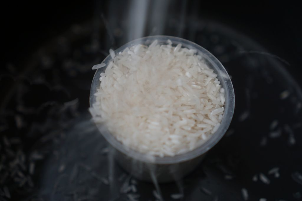 Warga menuang beras ke dalam gelas takar di Kota Balikpapan, Kalimantan Timur, Minggu (25/2/2024).