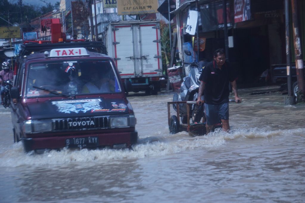 Warga melintasi banjir di Kawunganten, Cilacap, Jawa Tengah, Sabtu (8/10/2022).