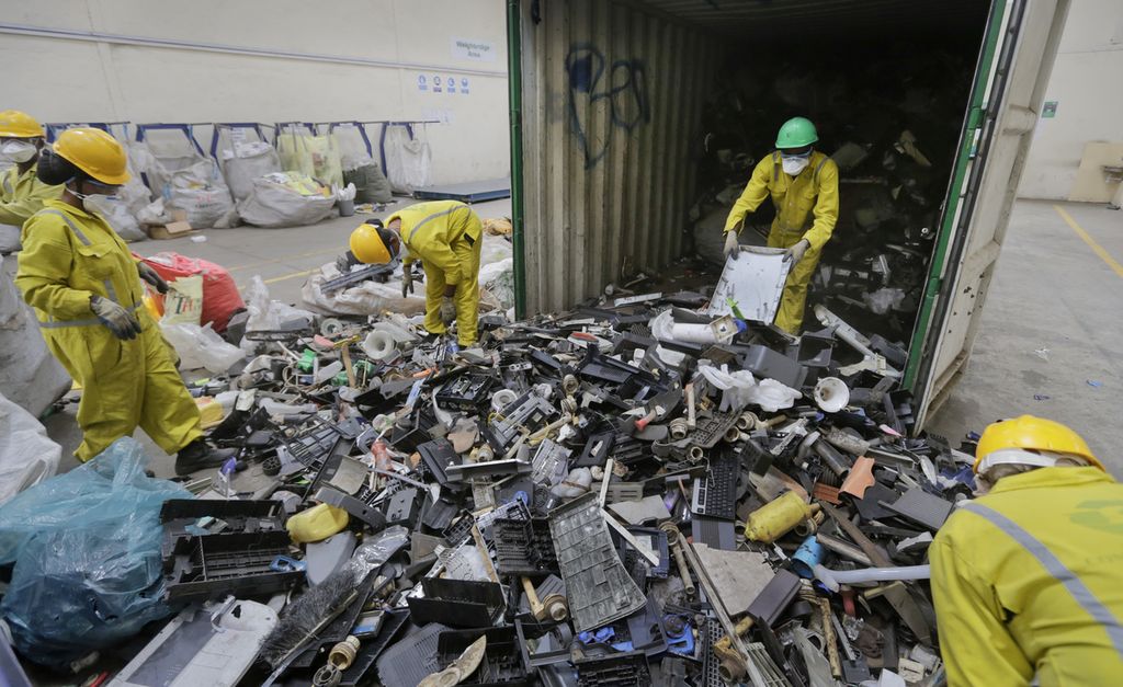 Dalam foto pada 18 Agustus 2014, para pekerja membongkar dan memilah wadah berisi sampah elektronik yang dikumpulkan dari daerah kumuh Nairobi, Kenya, dan dibawa untuk didaur ulang.
