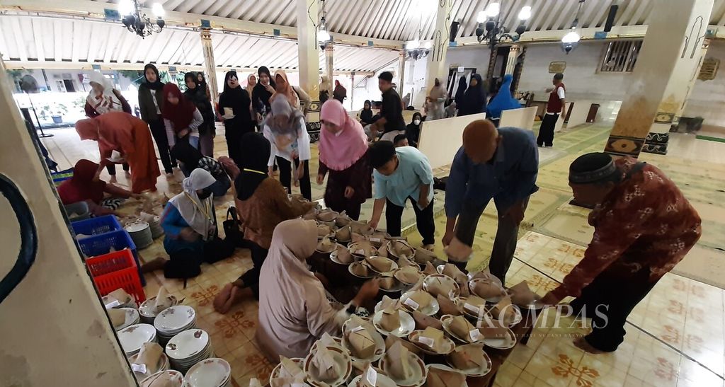 Jemaah mengambil bungkusan berisi nasi dan gulai kambing yang disajikan cuma-cuma untuk berbuka puasa di Masjid Gedhe Kauman, Kota Yogyakarta, Kamis (14/3/2024). 