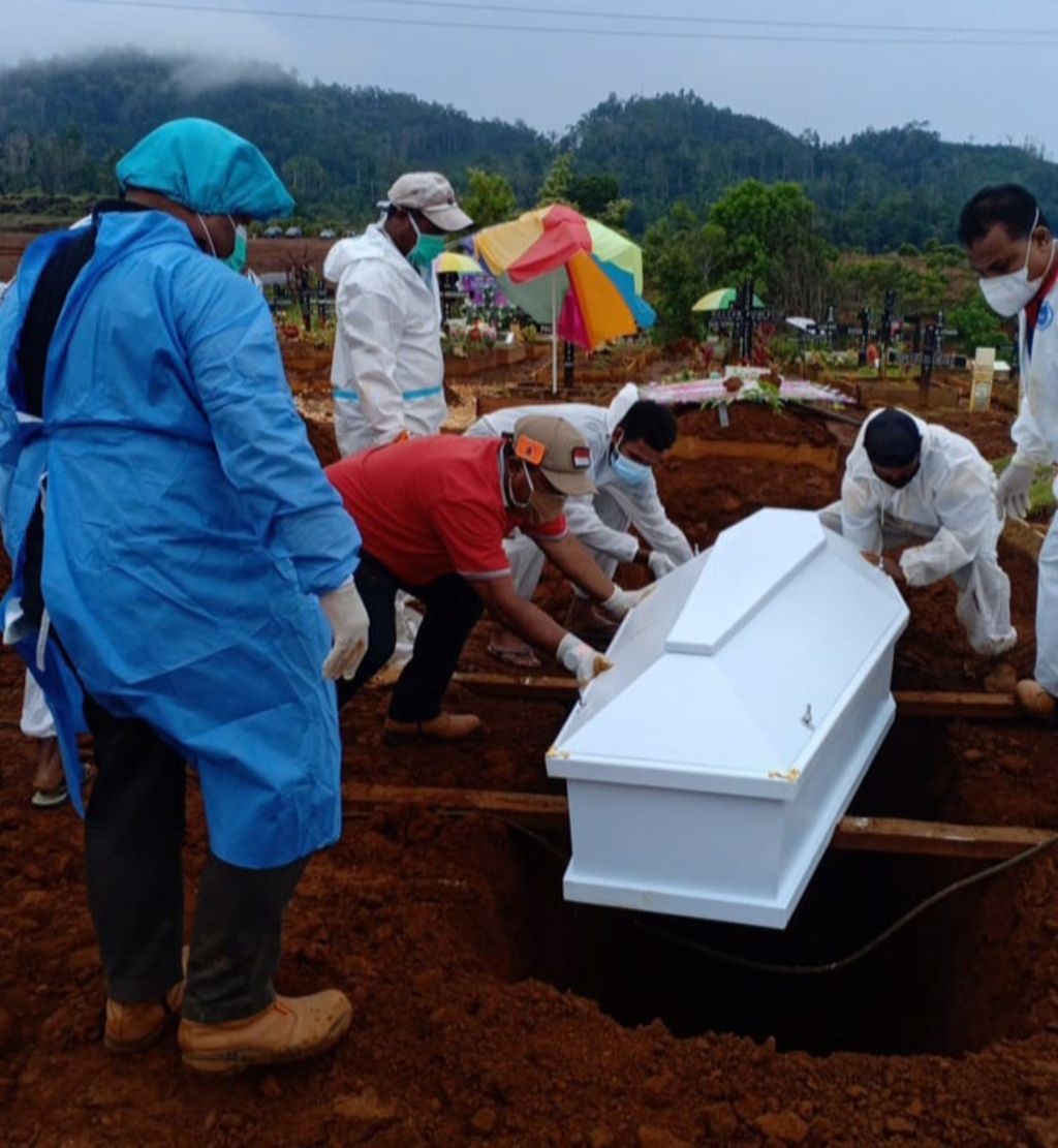 Tim relawan memakamkan jenazah salah seorang warga yang terpapar Covid-19 di Kota Jayapura, Papua, pada 9 Juli 2021. Kota Jayapura menempati peringkat pertama angka kematian akibat Covid-19 di Papua.