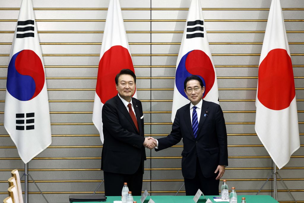 Presiden Korea Selatan Yoon Suk Yeol (kiri) dan Perdana Menteri Jepang Fumio Kishida (kanan) berjabat tangan menjelang pertemuan bilateral di Kantor Perdana Menteri di Tokyo, Jepang, Kamis (16/3/2023). 