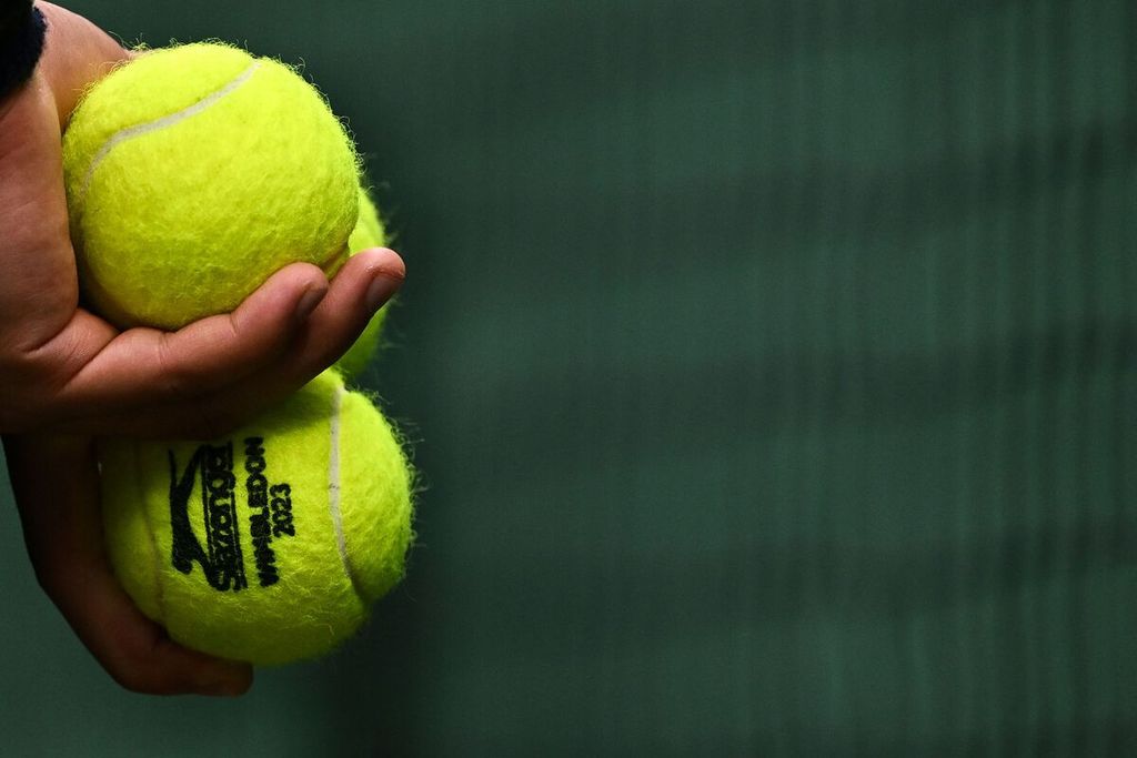 Seorang <i>ball boy</i> menggenggam bola resmi Wimbledon pada laga Daniil Medvedev (Rusia) versus Marton Fucsovics (Hongaria) di All England Tennis Club, Wimbledon, Inggris, Sabtu (8/7/2023).