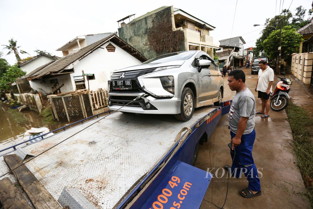 Petugas mengevakuasi mobil klien asuransi kendaraan yang terendam banjir di perumahan Ciledug Indah 1, Kota Tangerang, Banten, Jumat (3/1/2020). Permintaan klaim asuransi kendaraan dari pemegang polis akibat dampak dari banjir diproyeksikan meningkat. 