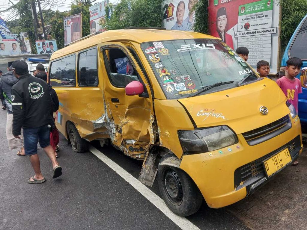 Warga menyaksikan kondisi angkot ringsek setelah mengalami kecelakaan beruntun di Jalan Raya Puncak Km 85, Tugu Selatan, Cisarua, Kabupaten Bogor, Jawa Barat, yang melibatkan sembilan kendaraan, Selasa (23/1/2024).