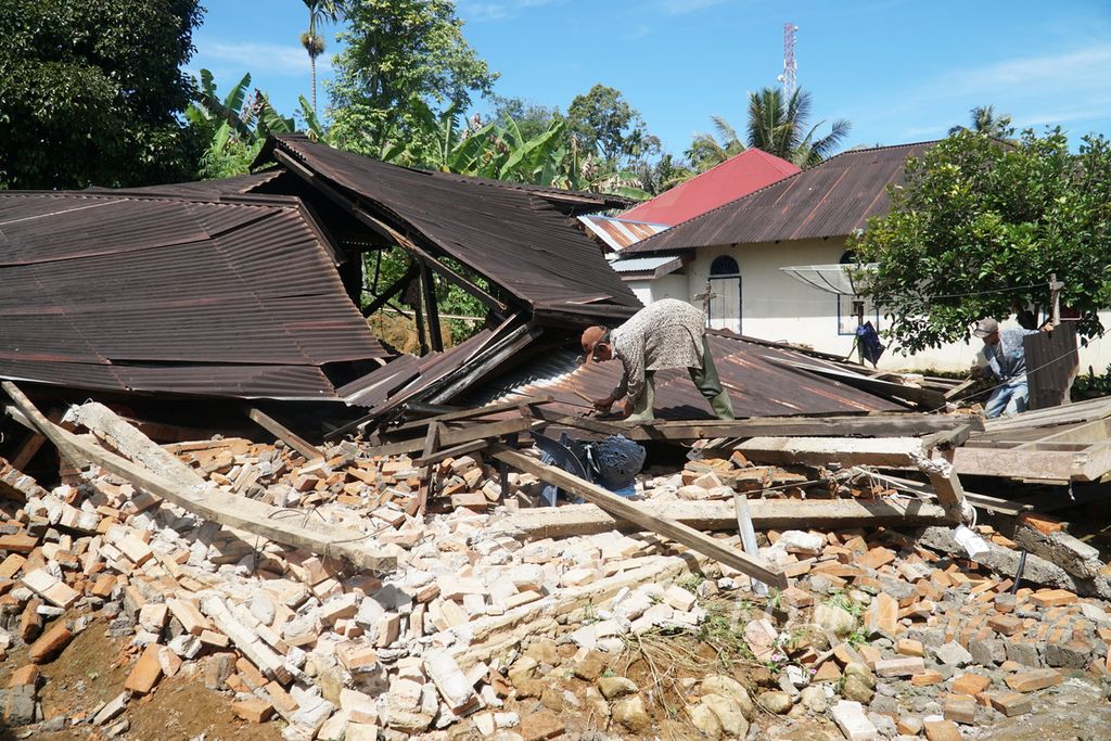 Warga membersihkan dan mengambil material yang masih bisa dipakai dari reruntuhan rumah rusak akibat gempa di Jorong Timbo Abu, Nagari Kajai, Kecamatan Talamau, Pasaman Barat, Sumatera Barat, Sabtu (12/3/2022). 