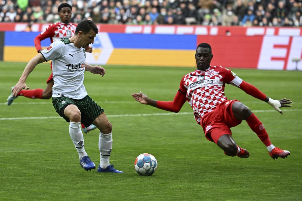 Moenchengladbach's Stefan Lainer, left, and Moussa Niakhate of Mainz fight for the ball during the German Bundesliga soccer match between Borussia Moenchengladbach and Mainz, at the Borussia Park stadium in Moenchengladbach, Germany, Sunday, April 3, 2022. 