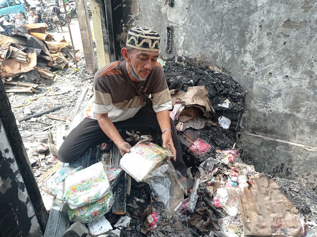 Pemilik gudang mengorek-ngorek dagangan yang bisa diselamatkan pasca-kebakaran 400 bangunan pertokoan dan rumah di Pasar Gembrong dan RT 002, 003, 004, 005, dan 006 RW 001, Kelurahan Cipinang Besar Utara, Kecamatan Jatinegara, Jakarta Timur, Selasa (26/4/2022).