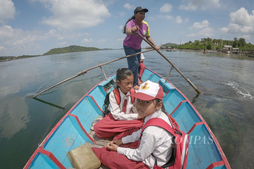 A resident of the Sea Tribe, Ida, takes the children of the Sea Tribe to school using a canoe in Airframe Village, Tajur Biru Village, Temiang Pesisir District, Lingga Regency, Riau Islands, Monday (18/7/2022).