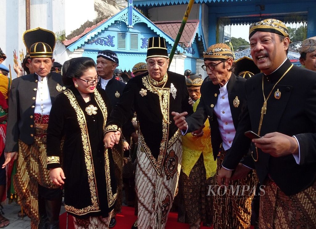 Raja Keraton Surakarta Paku Buwono XIII digandeng Permaisuri GKR Paku Buwono berjalan menuju Pagelaran Keraton Surakarta untuk mengikuti Kirab Agung Peringatan Kenaikan Takhta Paku Buwono XIII yang ke-14 di Solo, Jawa Tengah, Sabtu (5/5/2018).