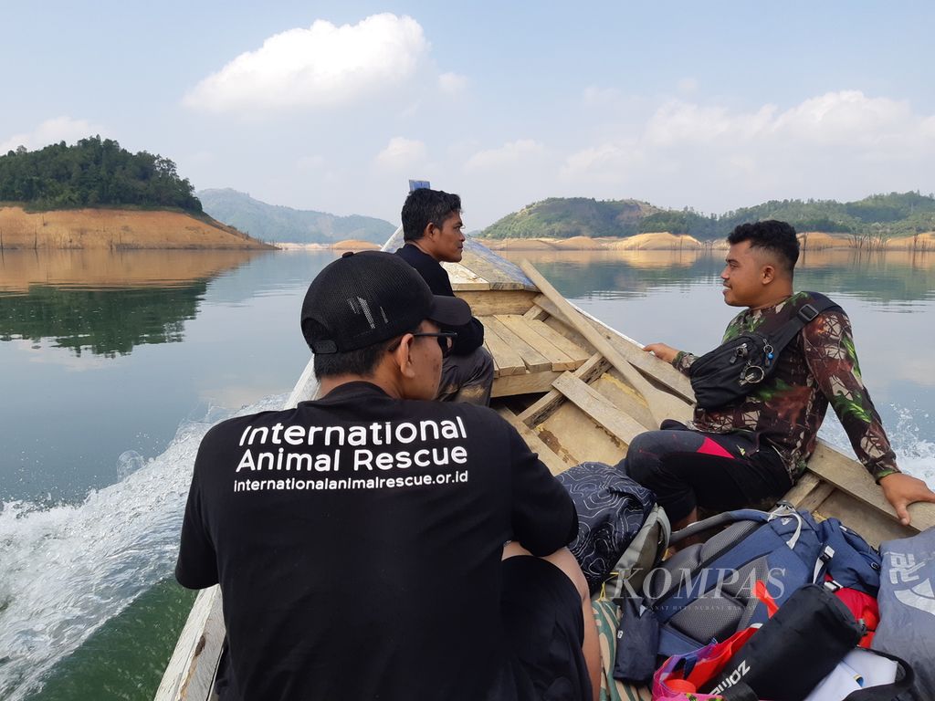 Tim Yayasan Inisiasi Alam Rehabilitasi Indonesia (YIARI) harus menyeberangi Bendungan Batutegi seusai meninjau Pusat Riset Way Rilau yang berada di dalam Hutan Lindung Batutegi, Lampung, (17/9/2023). Pusat riset itu menjadi markas para penjaga Hutan Lindung Batutegi. 
