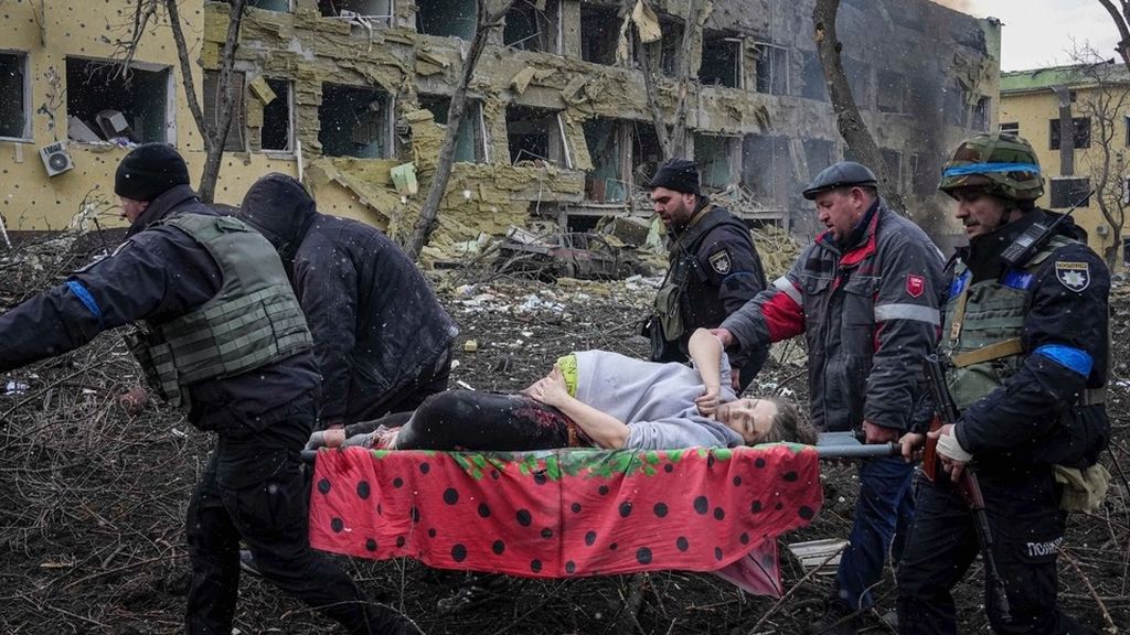 Pekerja dan sukarelawan darurat Ukraina membawa seorang wanita hamil yang terluka dari rumah sakit bersalin yang rusak akibat penembakan di Mariupol, Ukraina, Rabu (9/3/2022). Rumah sakit ibu dan anak itu hancur setelah dibom Rusia.