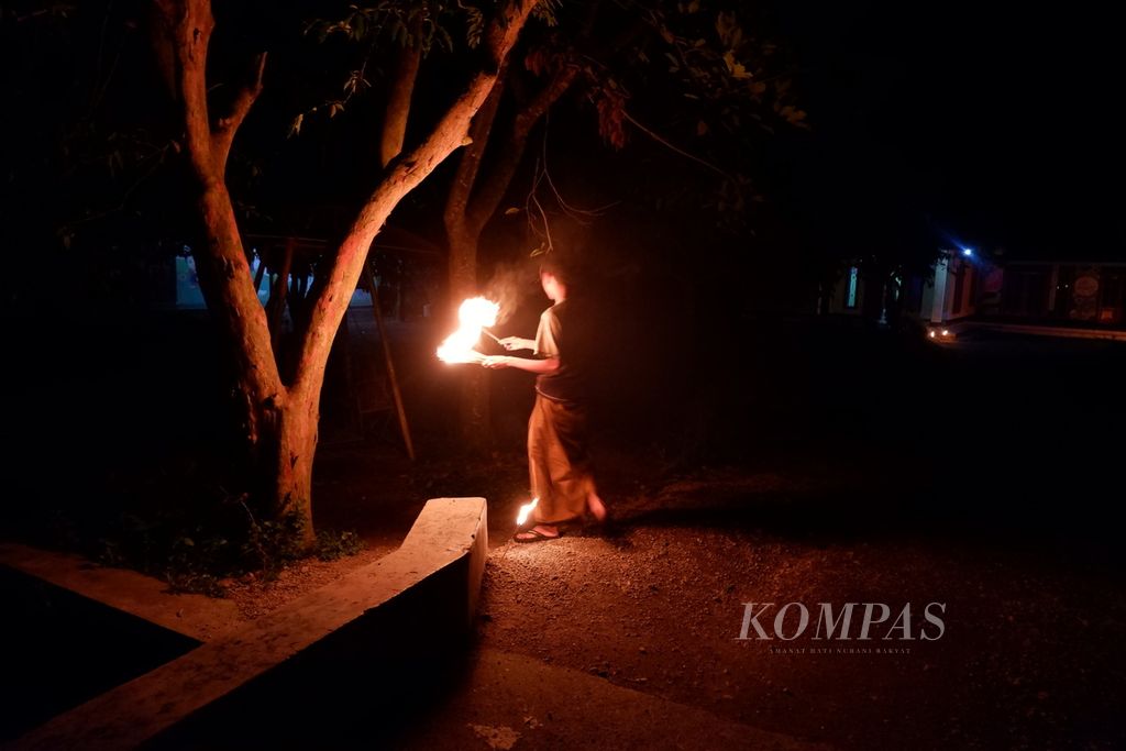 Warga membawa <i>dila jojor</i> (lampu <i>jojor</i>) dalam tradisi maleman ke area kebun miliknya di Dusun Kwang Jukut, Desa Pringgarata, Kabupaten Lombok Tengah, Nusa Tenggara Barat, Jumat (22/4/2022) malam. Maleman adalah tradisi yang digelar sebagian masyarakat Muslim di Lombok pada malam ganjil di sepuluh hari terakhir Ramadhan untuk menyambut malam Lailatul Qadar.