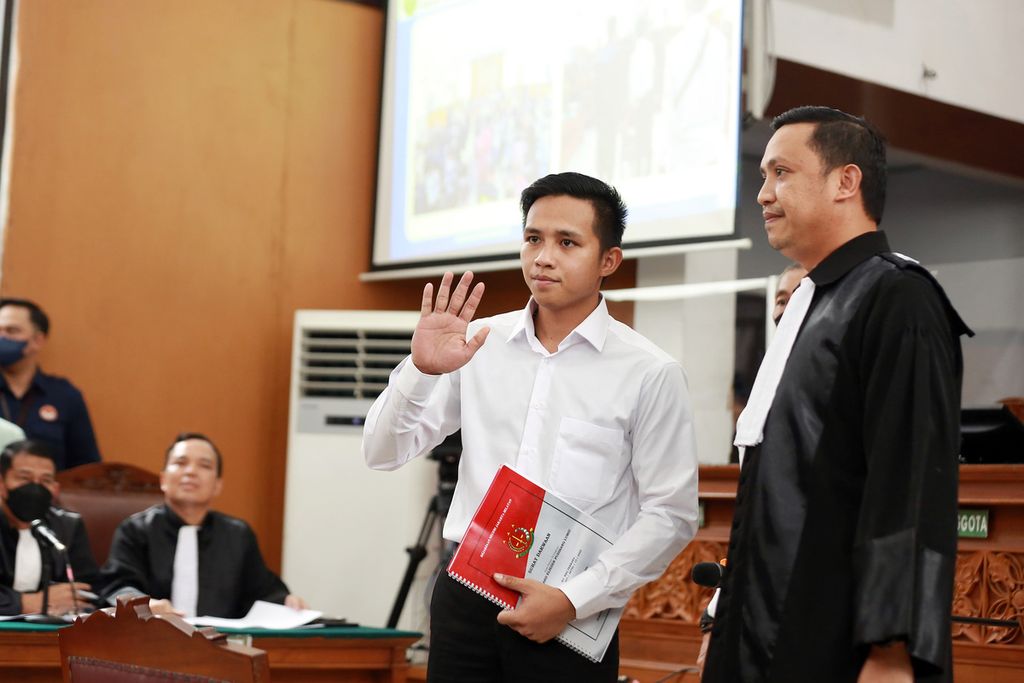 Terdakwa kasus pembunuhan Brigadir J (Nofriansyah Yosua Hutabarat), Richard Eliezer, melambaikan tangan kepada awak media pada saat menjalani sidang perdana di Pengadilan Negeri Jakarta Selatan, Selasa (18/10/2022). 