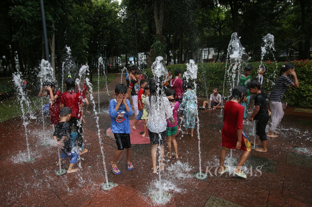 Anak-anak bermain air mancur yang menjadi salah satu daya tarik Taman Puring di Kebayoran Baru, Jakarta Selatan, Rabu (1/5/2024). Taman Puring menjadi salah satu taman kota yang ramai dikunjungi warga pada hari libur.