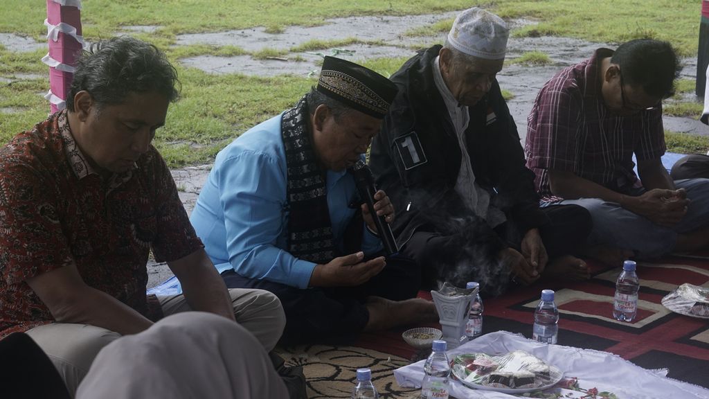 Raja Bashar Alimuddin Latar (berpeci putih) berdoa bersama Direktur Jenderal Kebudayaan Kemendikbudristek Hilmar Farid (paling kiri) dipimpin oleh pemuka adat setempat (berpeci hitam berbaju biru), Senin (20/6/2022) pagi. Orang Banda Eli, yaitu orang-orang Banda yang melarikan diri keluar Banda sejak 401 tahun silam, diundang untuk mengunjungi kampung halaman leluhur mereka. Di Benteng Nassau, Banda Neira, mereka mendoakan arwah para leluhur Banda yang dibantai VOC pada 1621 karena menolak usaha monopoli perdagangan pala dan rempah-rempah di Kepulauan Banda.