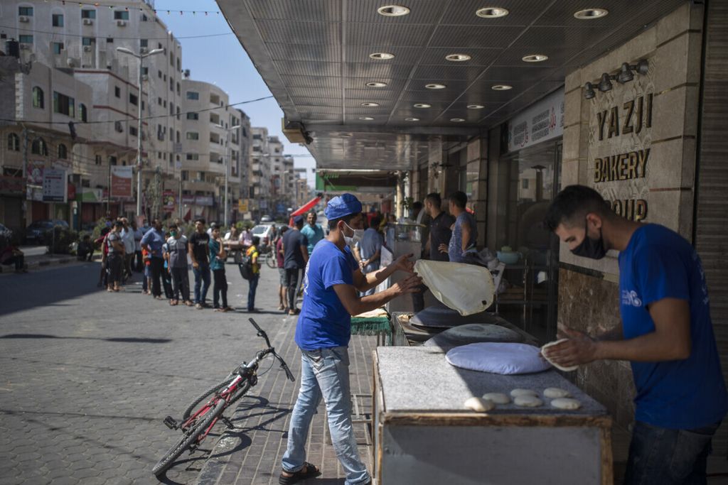 Warga antre untuk membeli roti menyusul diberlakukannya lockdown (penguncian) Kota Gaza selama 48 jam. Selasa (25/8/2020). Kasus ini dilaporkan setelah empat orang dari keluarga yang sama dinyatakan positif mengidap virus corona.