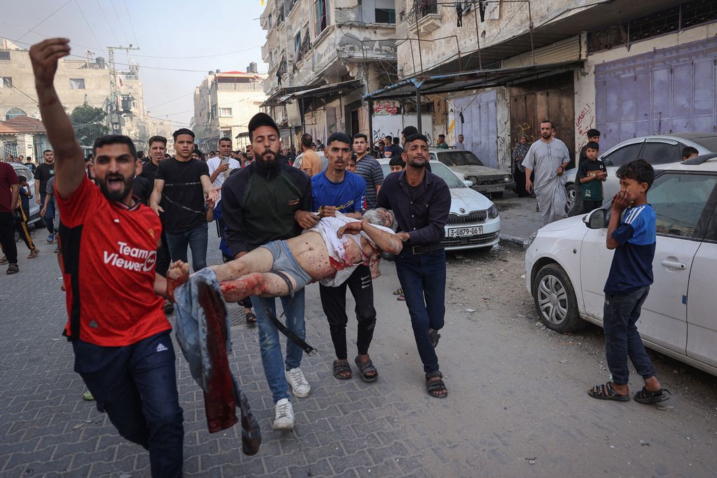 Warga Palestina menyelamatkan seorang laki-laki yang tertimpa puing akibat serangan udara Israel di Rafah, Jalur Gaza, 5 Mei 2024.