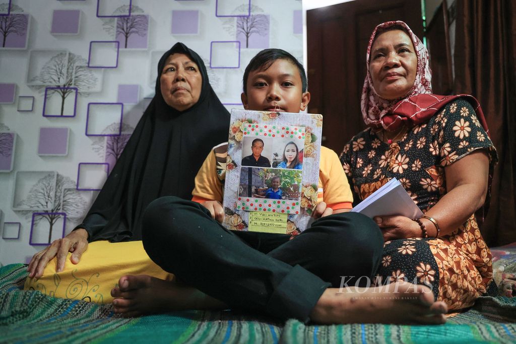 Muhammad Alfiansyah (11), korban selamat dari kerusuhan di Stadion Kanjuruhan, menunjukkan foto kedua orangtuanya saat berada di rumahnya di kawasan Bareng, Malang, Jawa Timur, Senin (3/10/2022). 