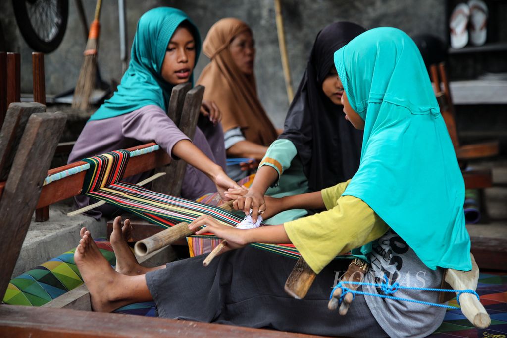 Suasana belajar tenun di Sekolah Tenun Kelompok Nina Penenun di Desa Pringgasela Selatan, Kecamatan Pringgasela, Kabupaten Lombok Timur, Nusa Tenggara Barat, Minggu (17/12/2023). Keberadaan sekolah ini diharapkan memunculkan generasi yang cinta dan suka menenun sehingga kerajinan tenun tetap lestari.