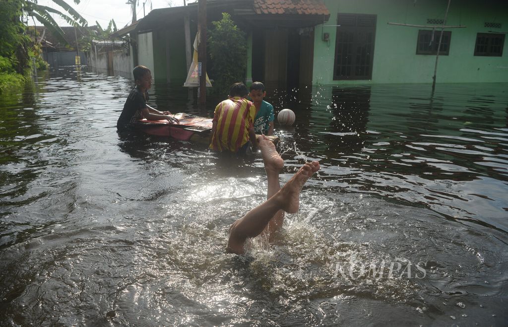 Anak-anak bermain air saat banjir pasang air laut melanda Kampung Tirto, Kota Pekalongan, Jawa Tengah, Selasa (24/5/2022). 
