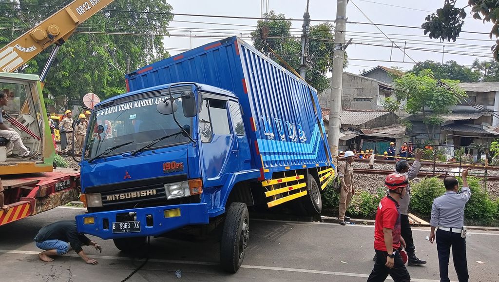 Proses evakuasi truk barang yang menabrak tiang listrik aliran atas (LAA) di jalur rel listrik di Km 17+5 antara Stasiun Pondok Ranji dan Kebayoran, Jalan Bintaro Permai IV, Pesanggrahan, Jakarta Selatan, Selasa (25/7/2023).